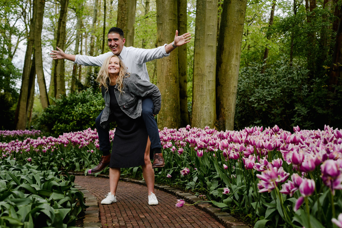 Newly engaged couple laughing together in spring flower garden at Keukenhof