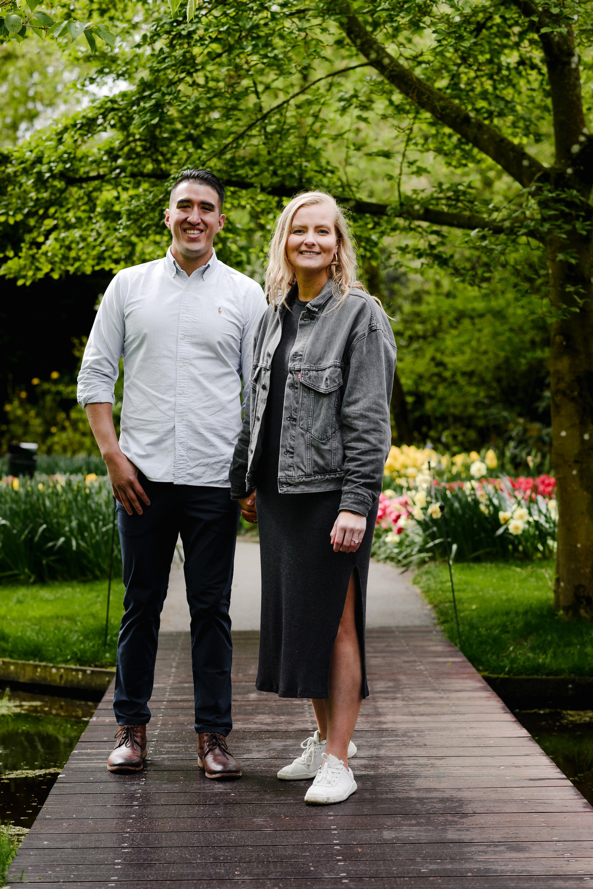 Couple standing together on garden bridge at Keukenhof during tulip season
