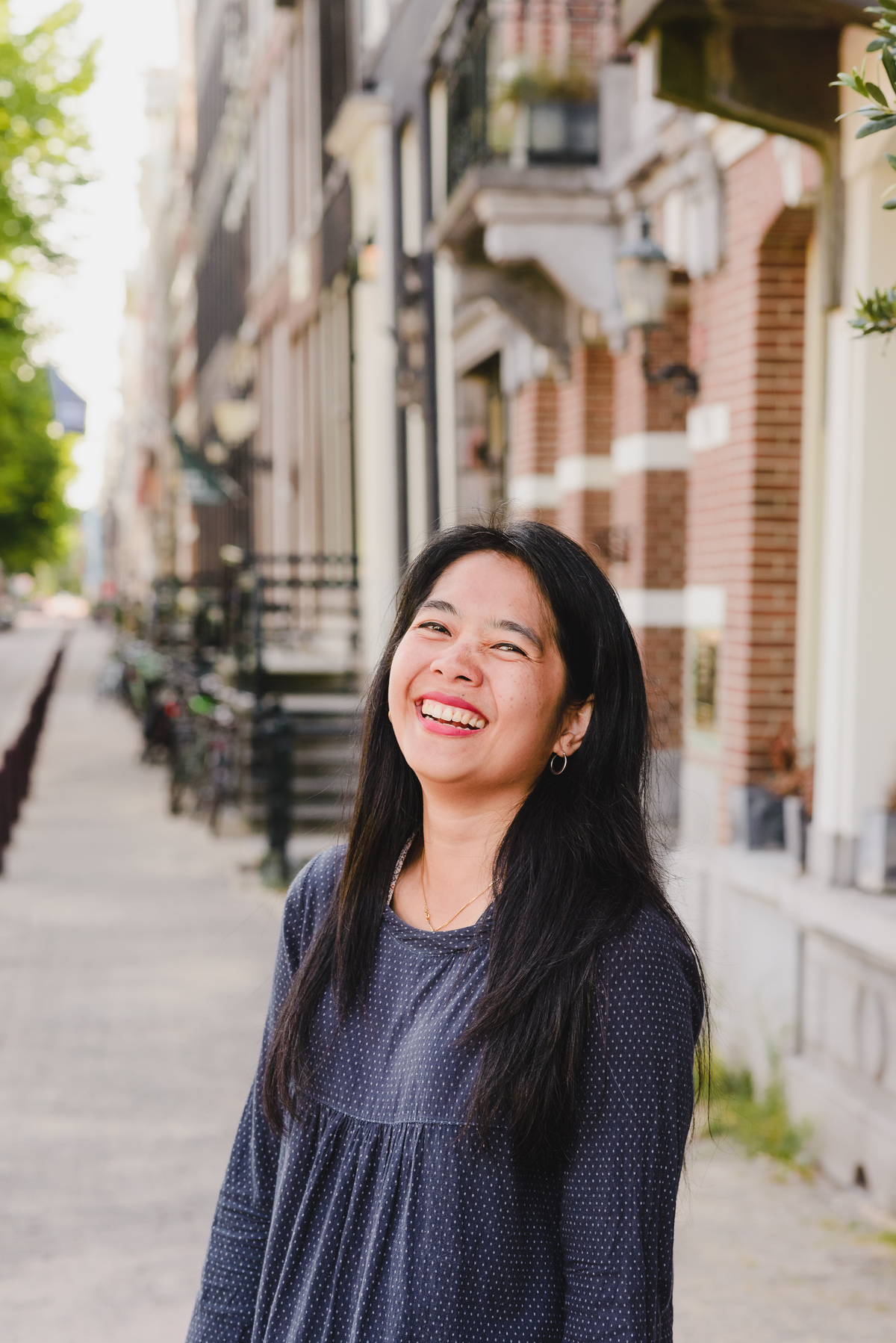 Close-up portrait of a woman smiling naturally on a quiet residential street in Amsterdam