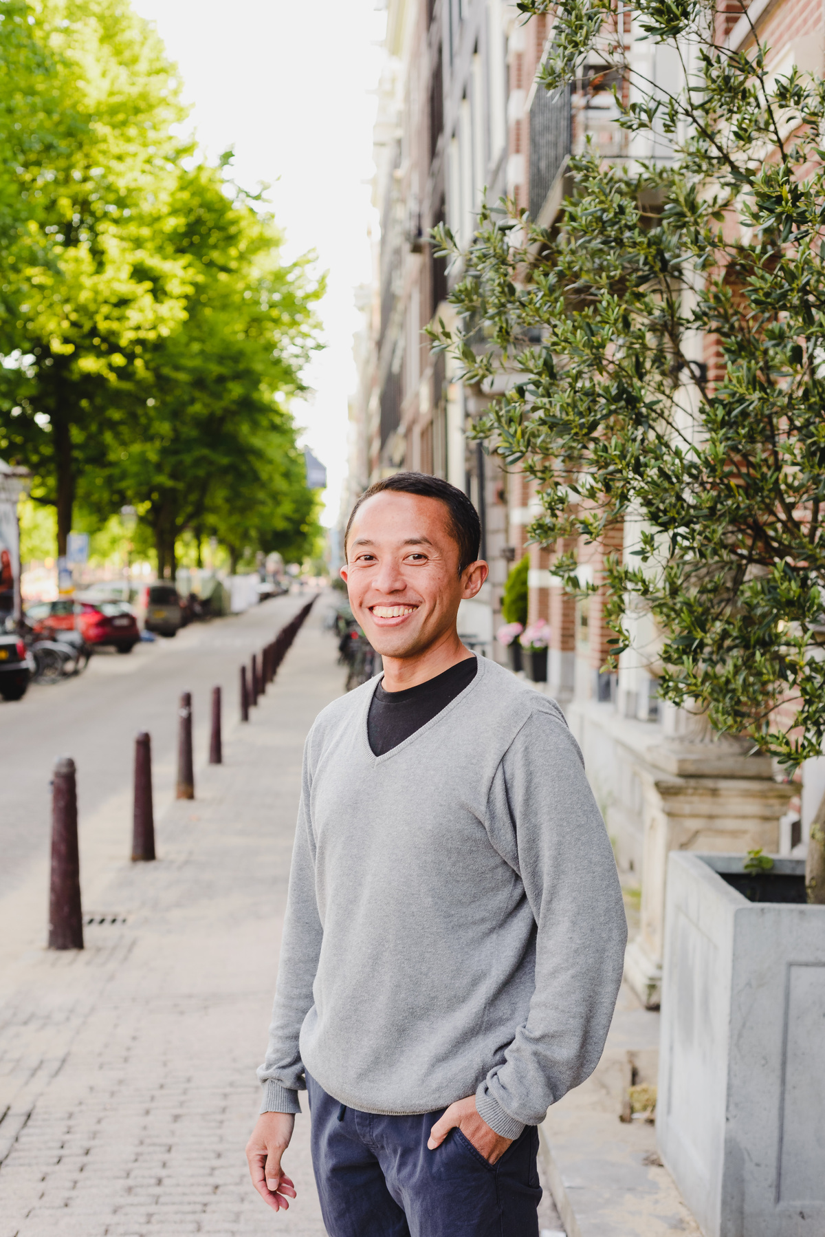Portrait of a man smiling on a tree-lined residential street in Amsterdam
