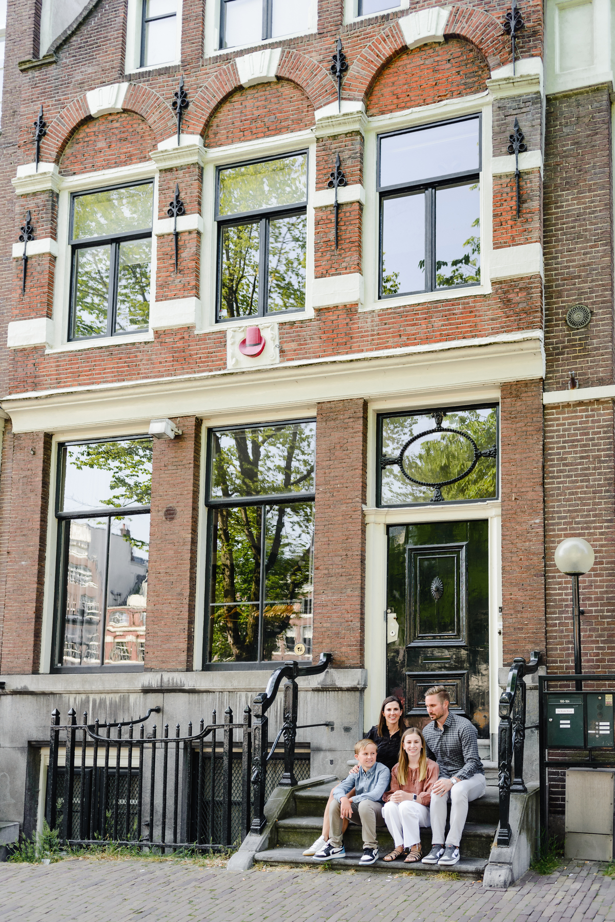 family sitting together on an Amsterdam house called de rode hoed in the canal belt of amsterdam