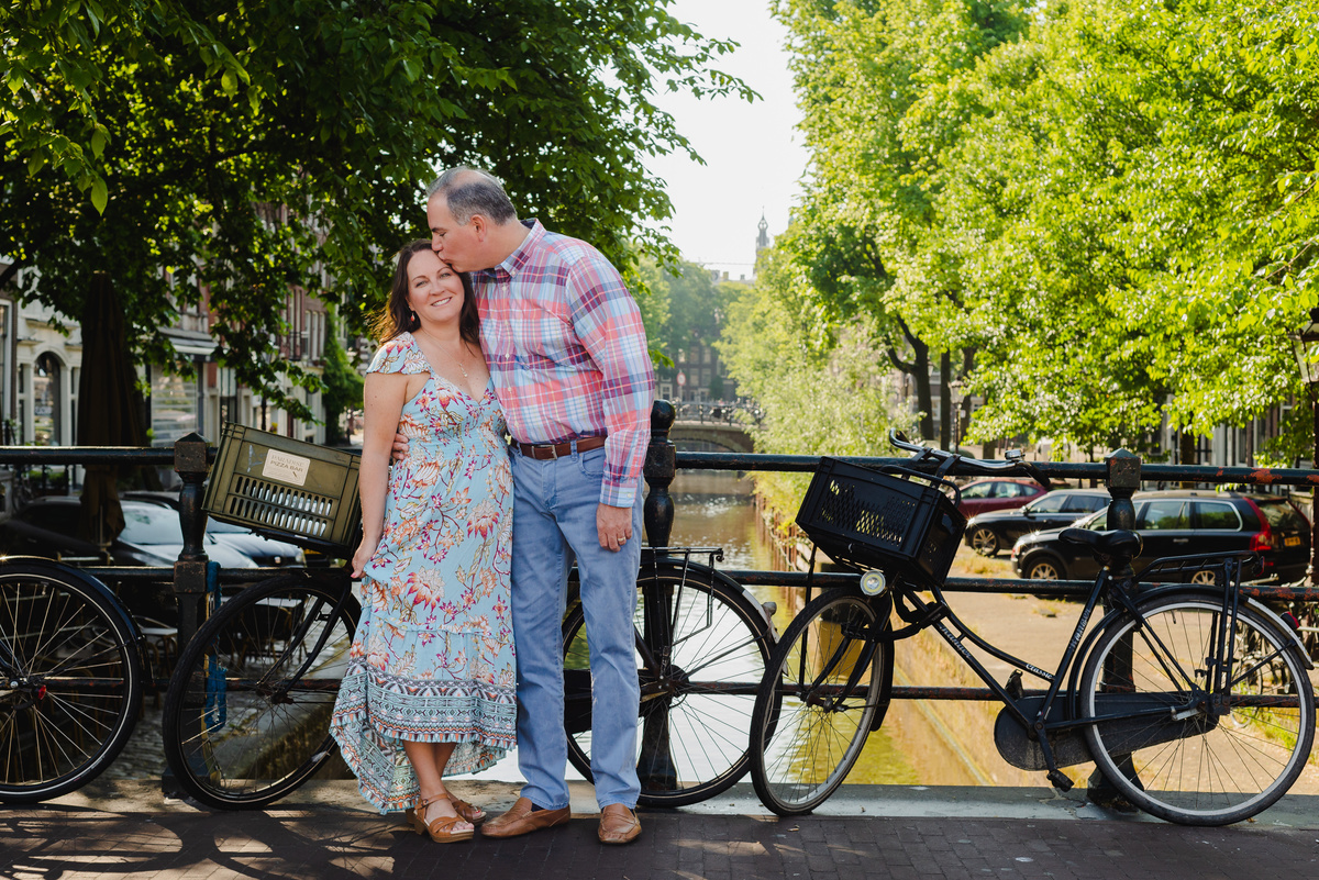 couple standing next to a canal bridge in amsterdam, Jordaan district, during a summer photo session