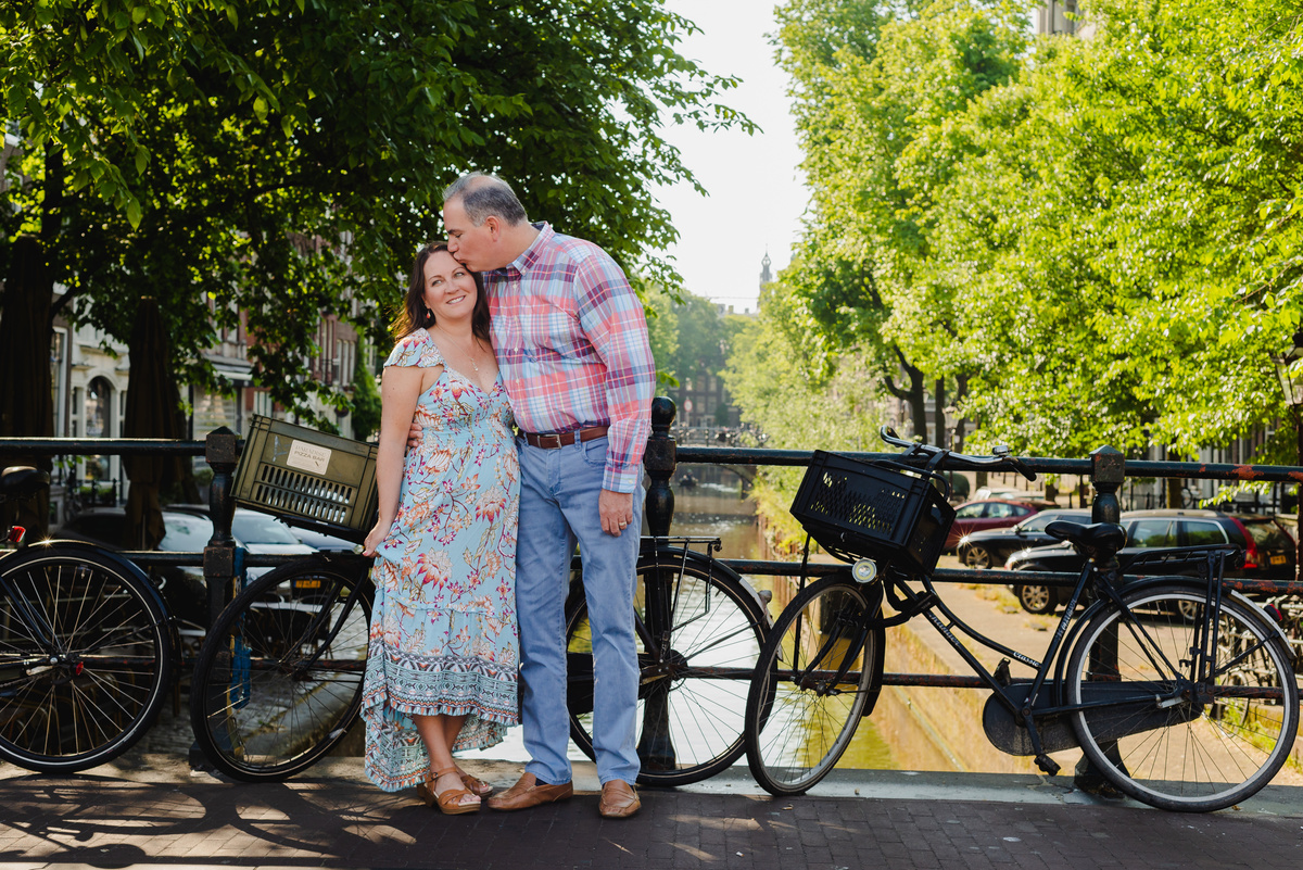 couple standing next to a canal bridge in amsterdam, Jordaan district, during a summer photo session