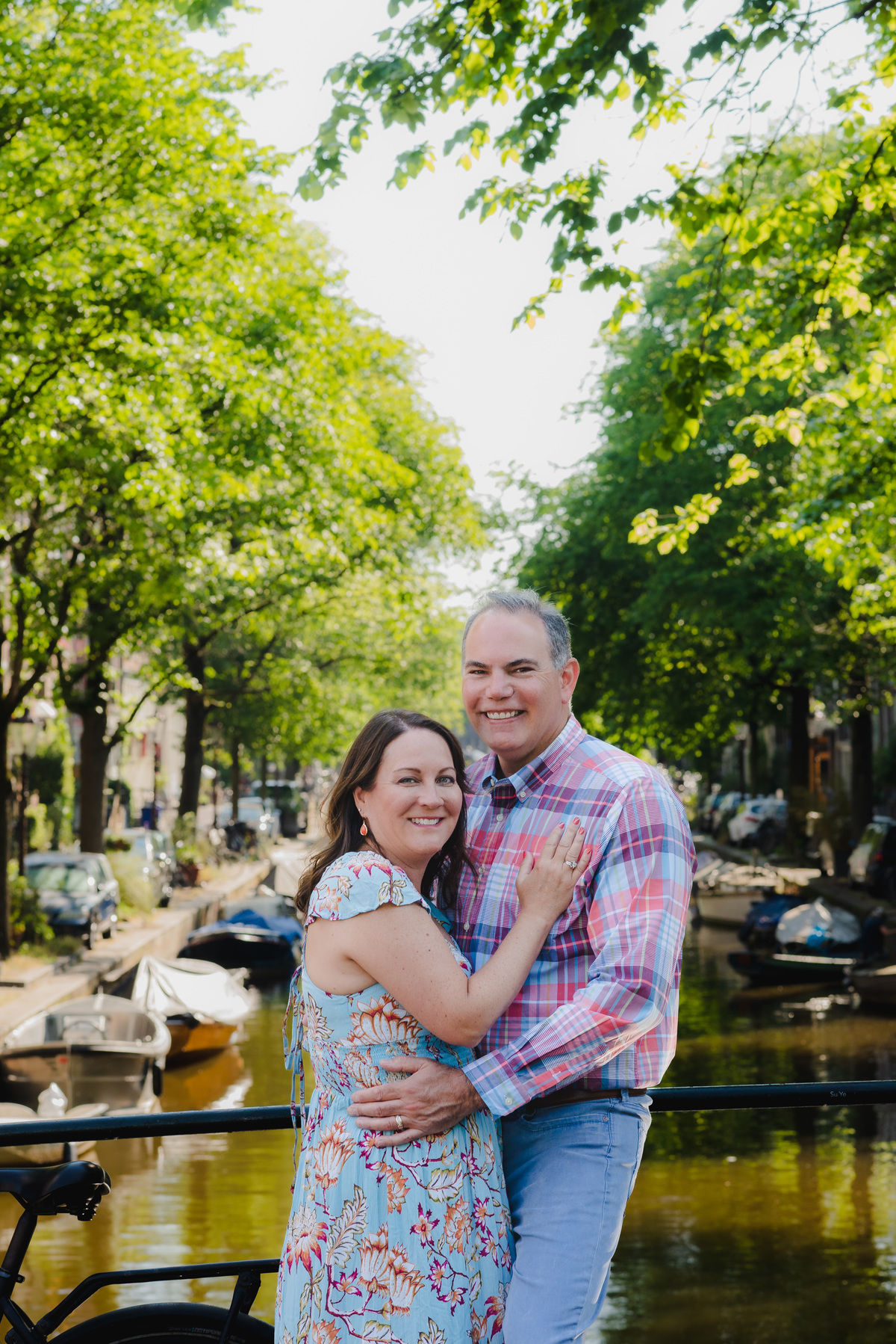 couple standing next to a canal bridge in amsterdam, Jordaan district, during a summer photo session
