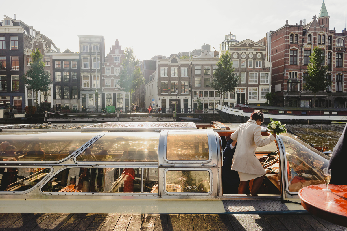bride entering canal boat right after gemmente wedding ceremony in Amsterdam