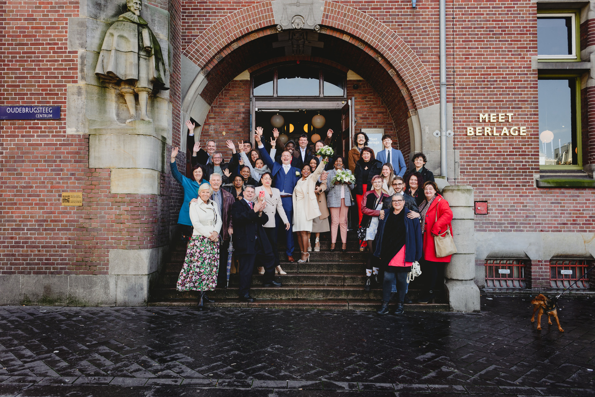 Wedding group photo in front of Berlage building on Damrak Amsterdam