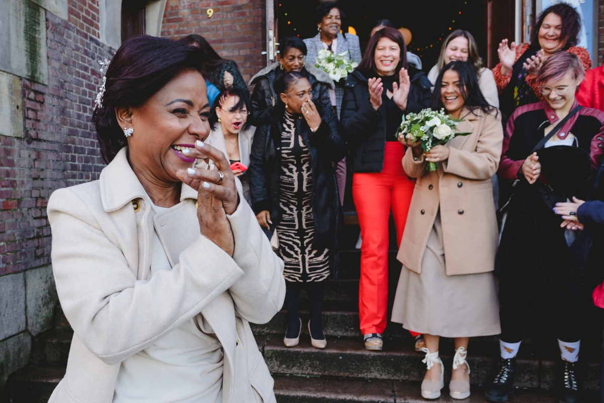 Bride throwing bouquet on Beurs van Berlage stairs after civil wedding in Amsterdam