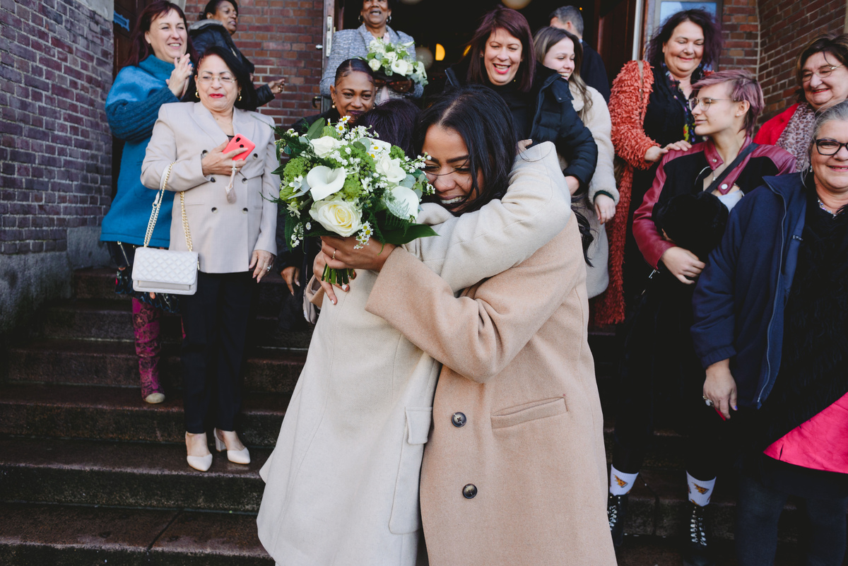 Bride throwing bouquet on Beurs van Berlage stairs after civil wedding in Amsterdam