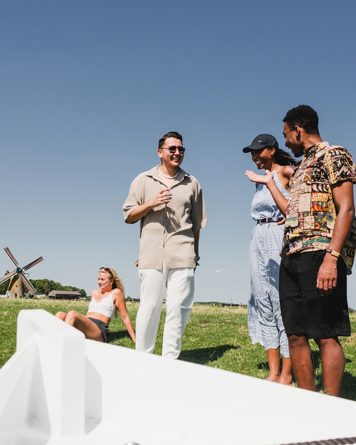 Friends relaxing and chatting on a boat while cruising through Leiden canals on a bright summer day.