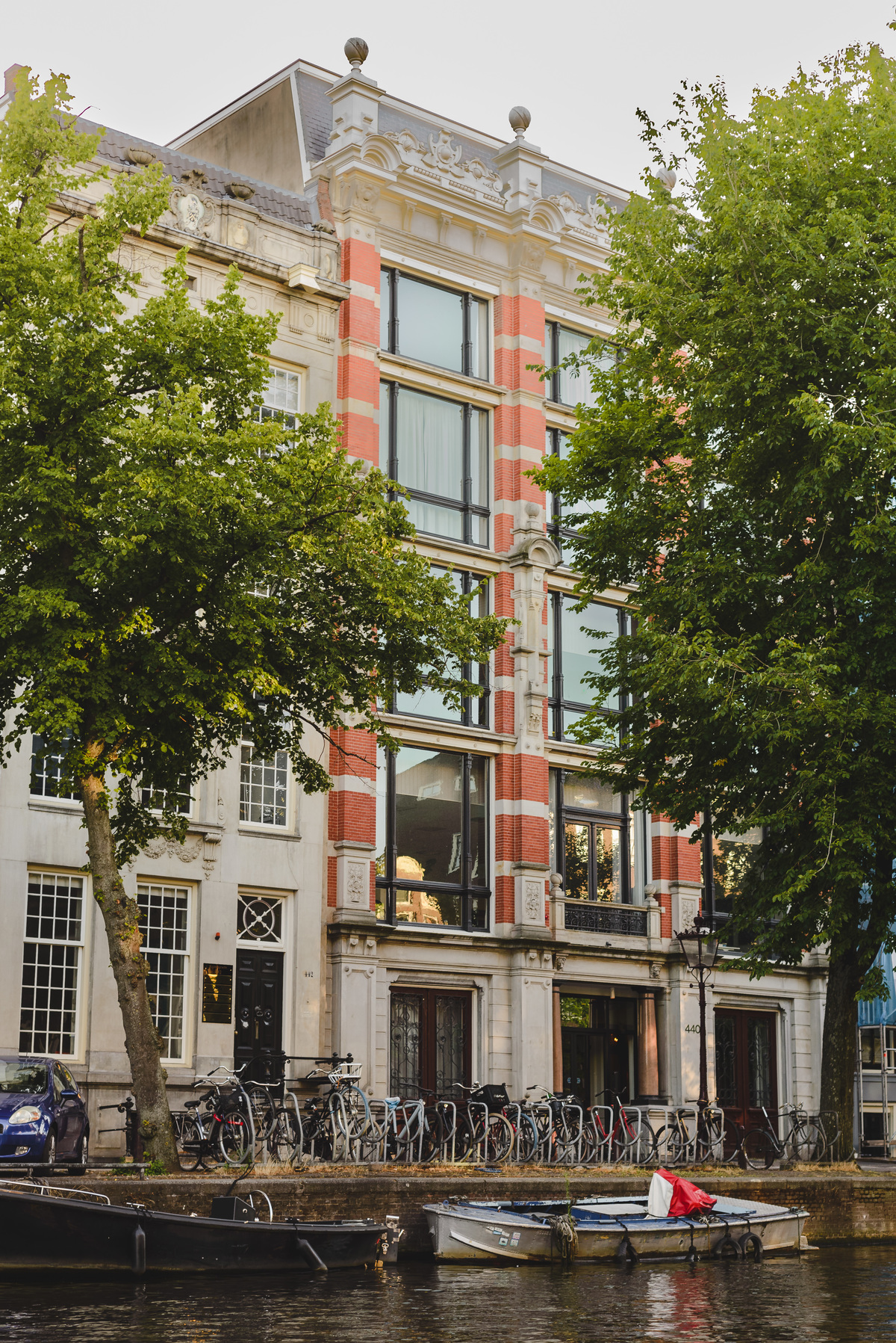 Historic canal houses in Amsterdam photographed from a boat during summer.