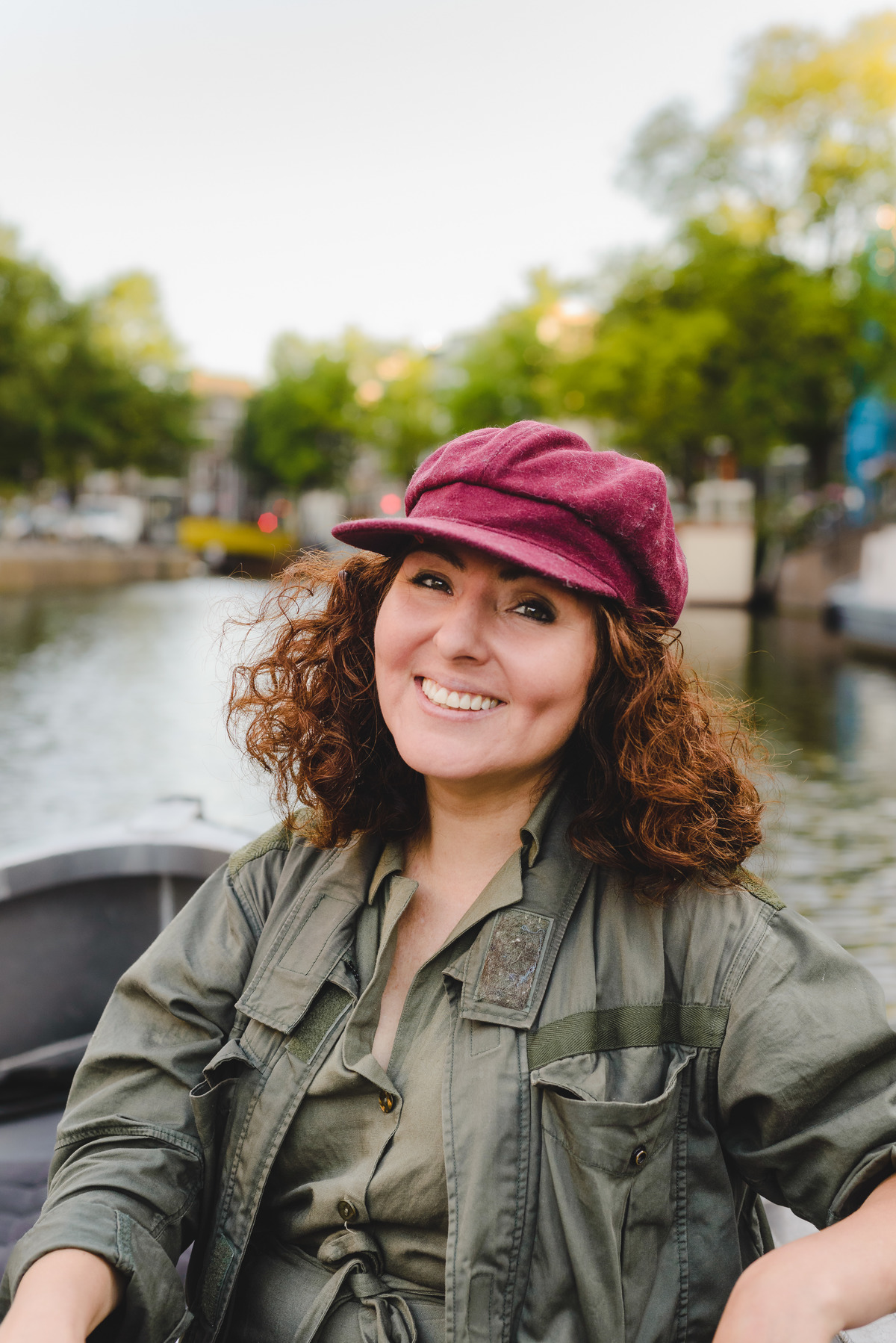Person smiling while on an electric boat through Amsterdam canals on a sunny summer day.