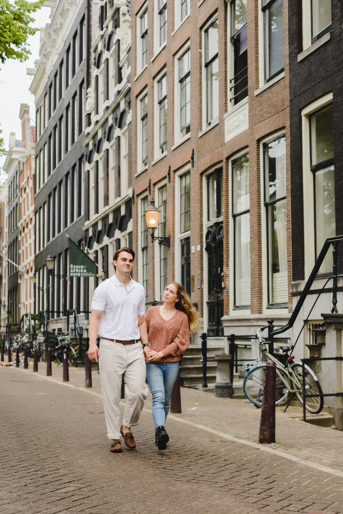 Couple walking together along a quiet Amsterdam street near the canals.