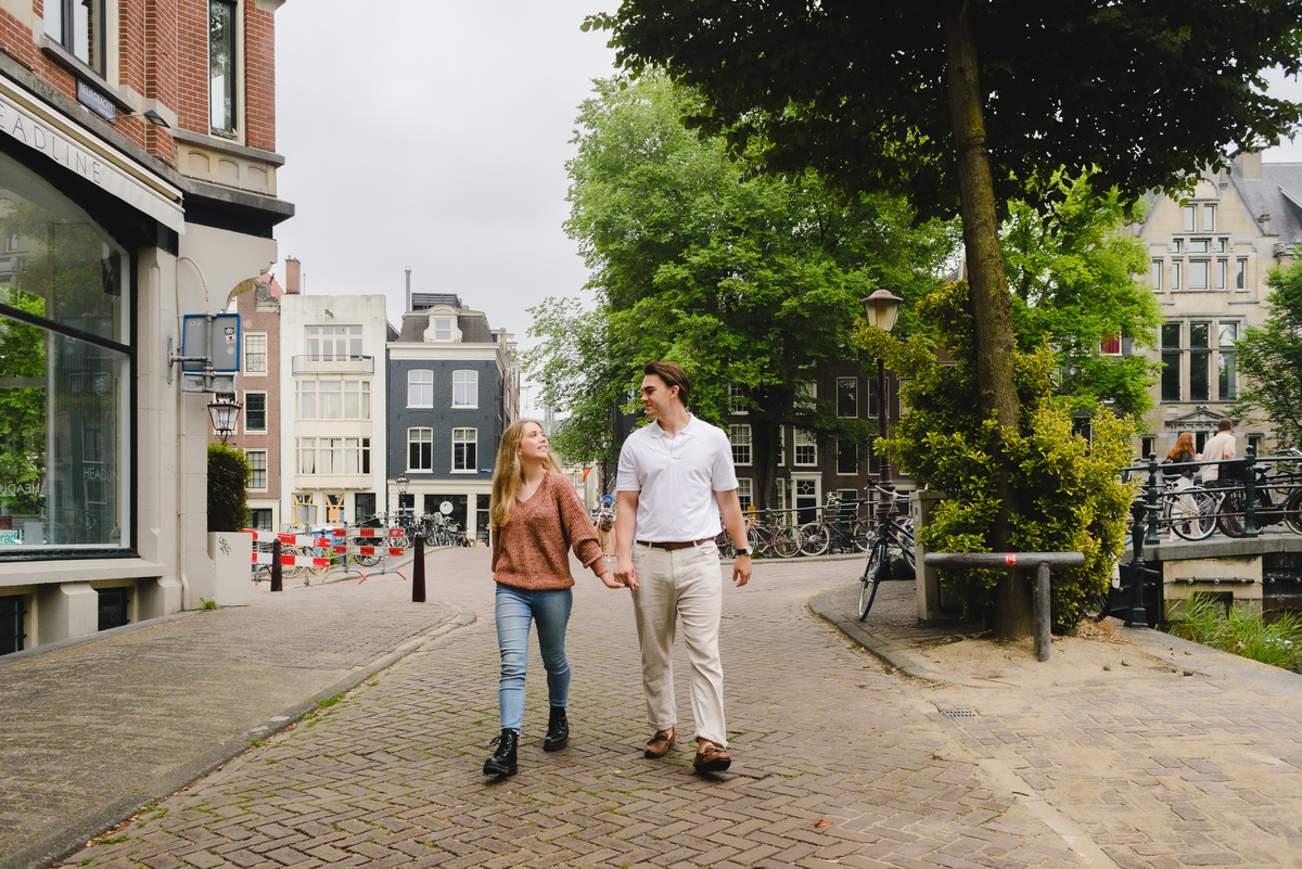 Couple walking together along a quiet Amsterdam street near the canals.