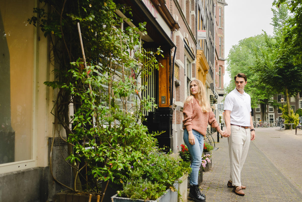 Documentary style couple photo capturing a relaxed walk near Amsterdam canals.