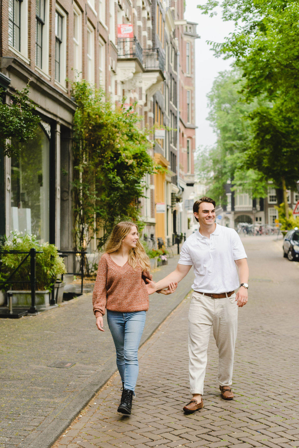 Couple walking together along a quiet Amsterdam street near the canals.