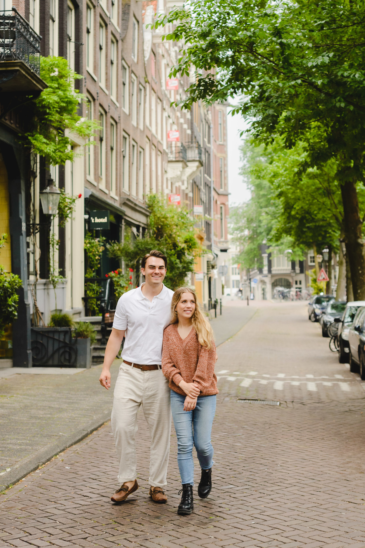 Documentary style couple photo capturing a relaxed walk near Amsterdam canals.