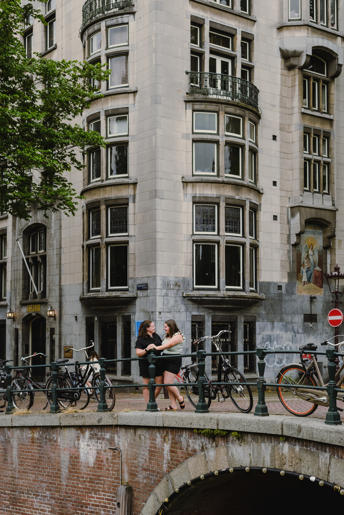 ouple photo highlighting Amsterdam architecture and canal-side buildings