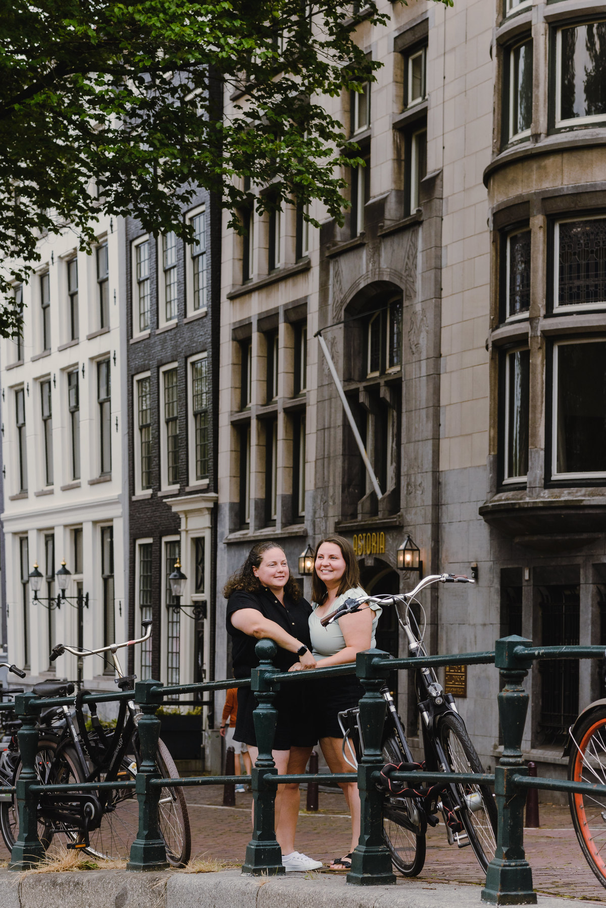 ouple photo highlighting Amsterdam architecture and canal-side buildings