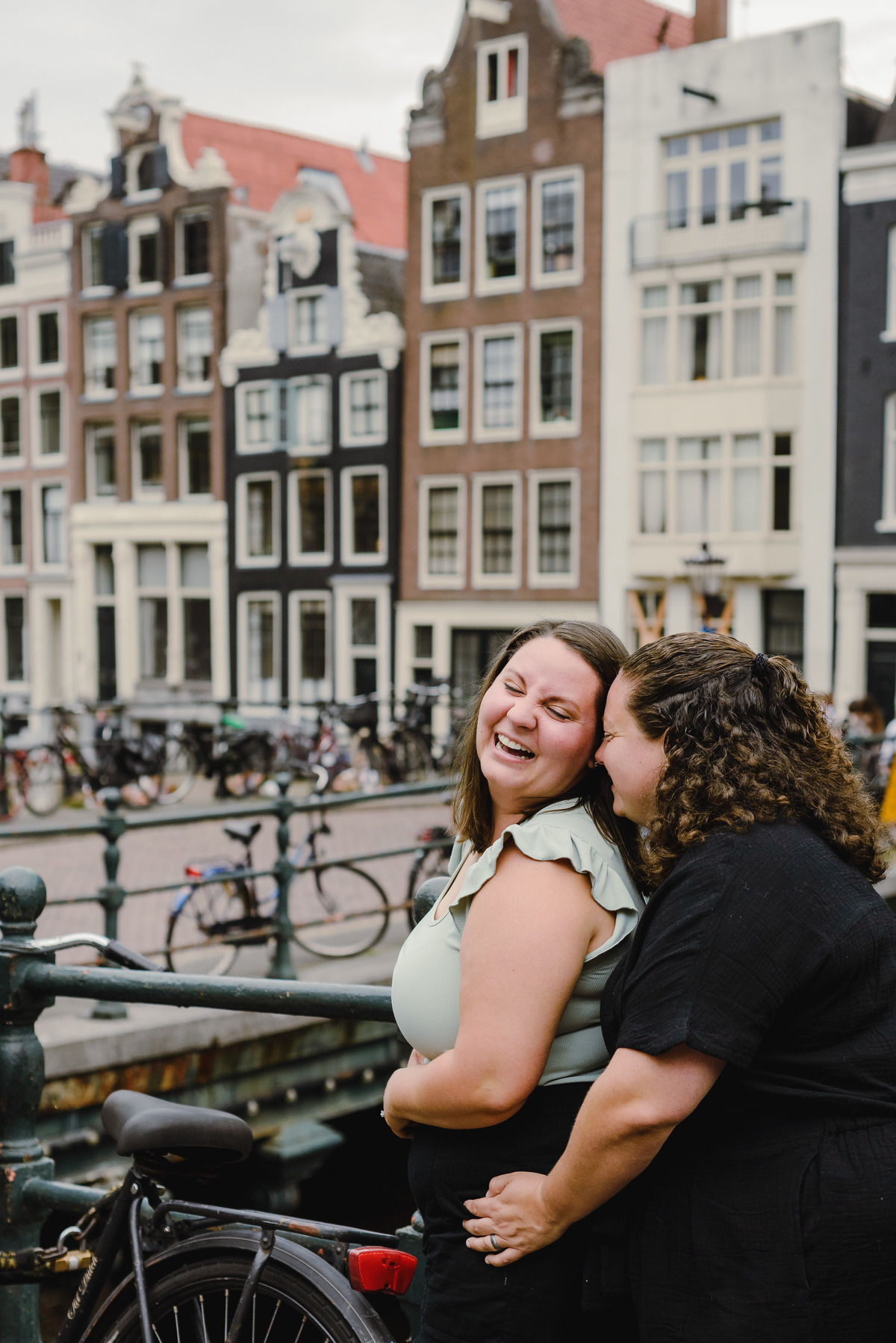 Playful same-sex couple laughing together during a relaxed Amsterdam photo shoot