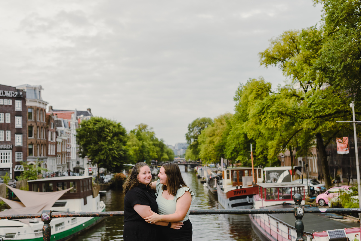 Same-sex couple photographed with historic Amsterdam architecture in the background