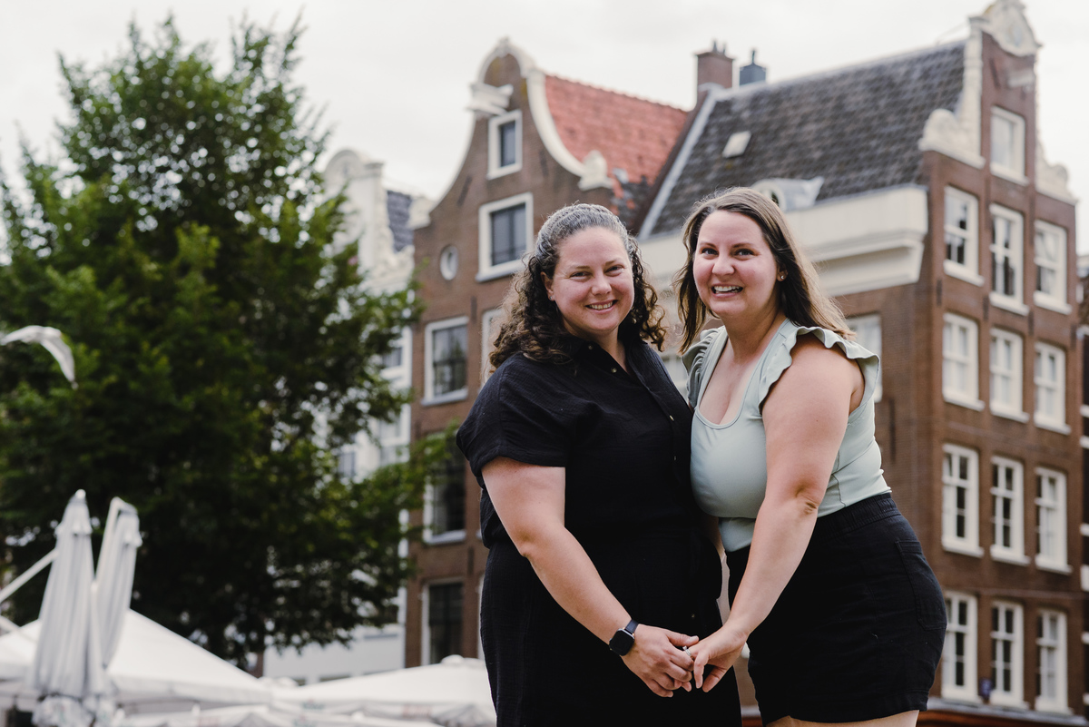 Playful same-sex couple laughing together during a relaxed Amsterdam photo shoot