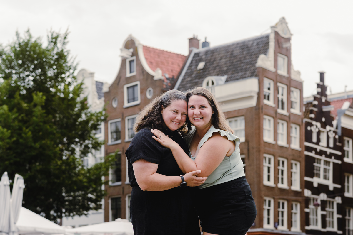 ouple photo highlighting Amsterdam architecture and canal-side buildings