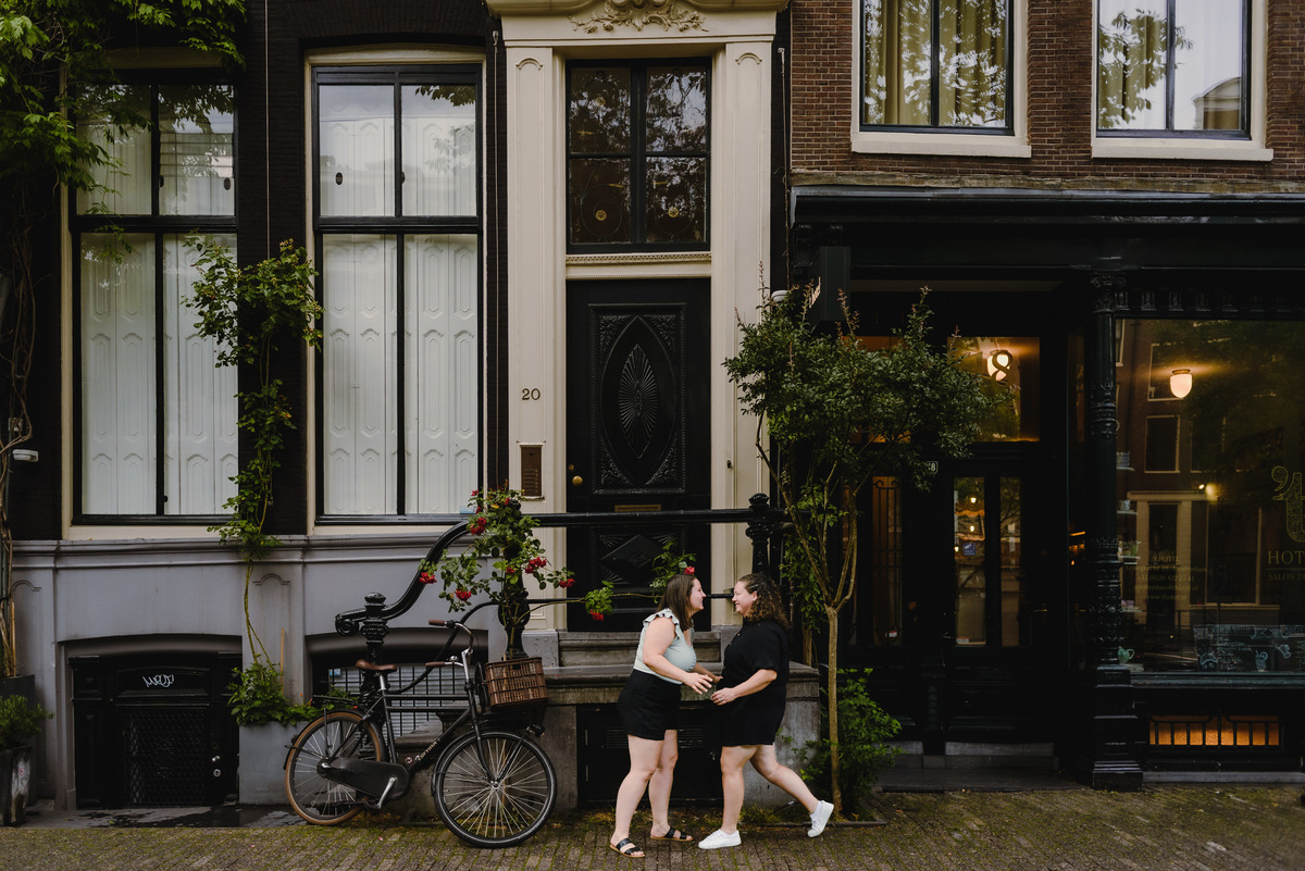 Playful same-sex couple laughing together during a relaxed Amsterdam photo shoot