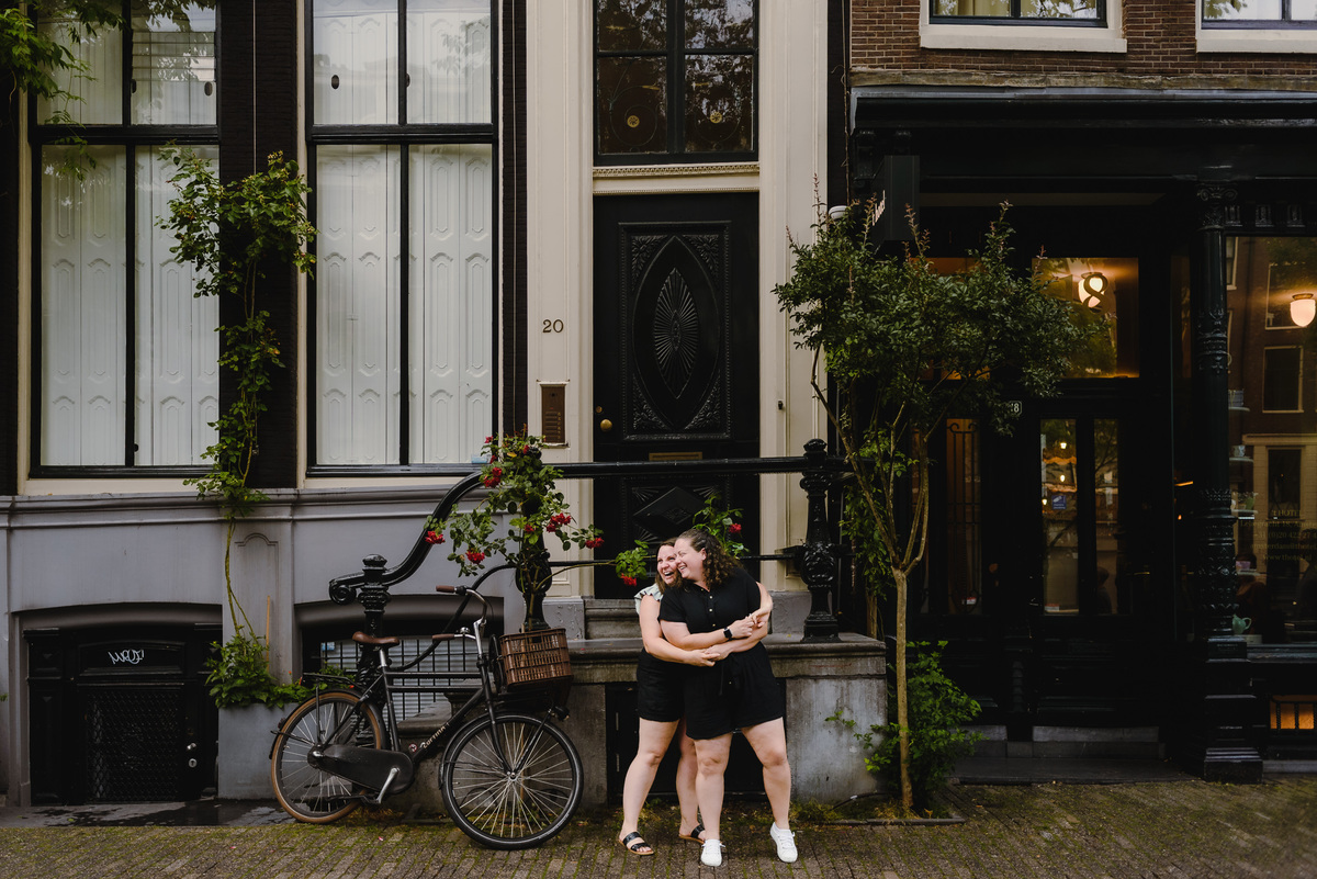 Playful same-sex couple laughing together during a relaxed Amsterdam photo shoot