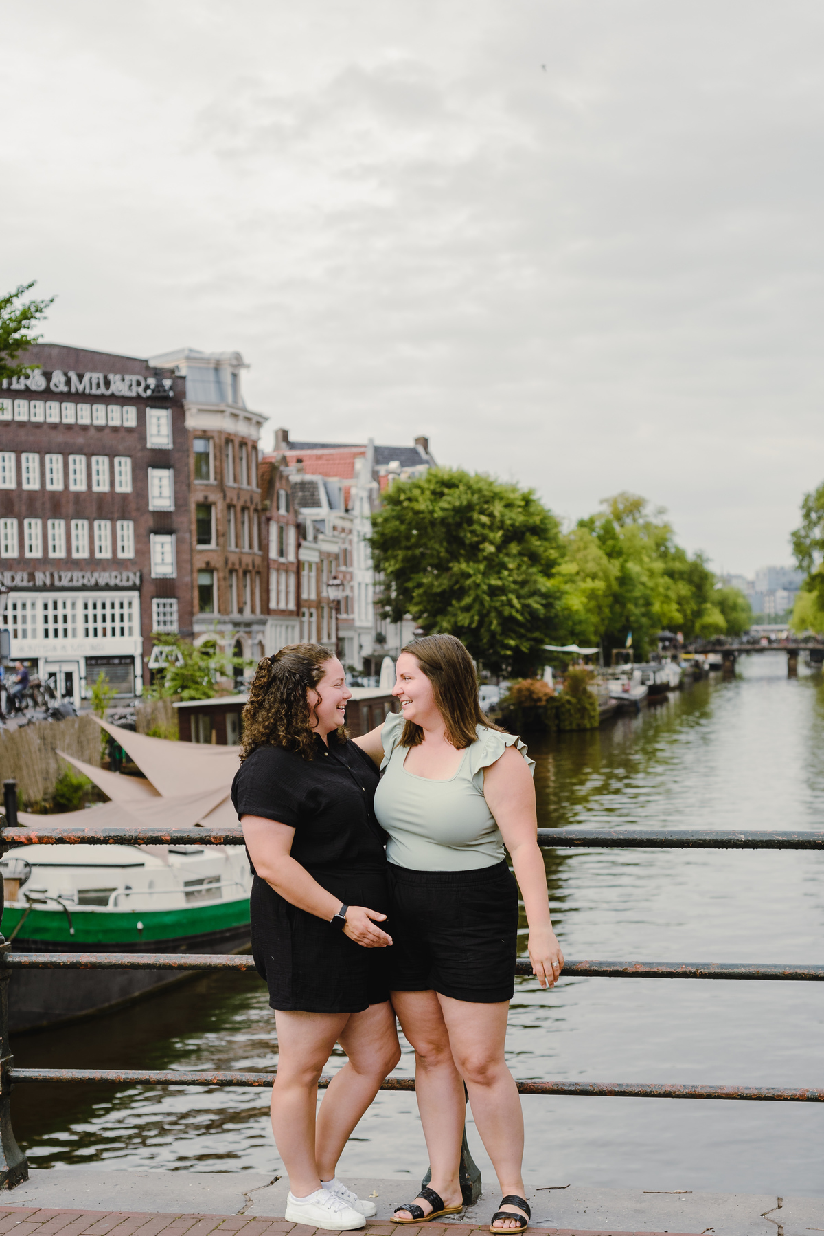 Same-sex couple photographed with historic Amsterdam architecture in the background