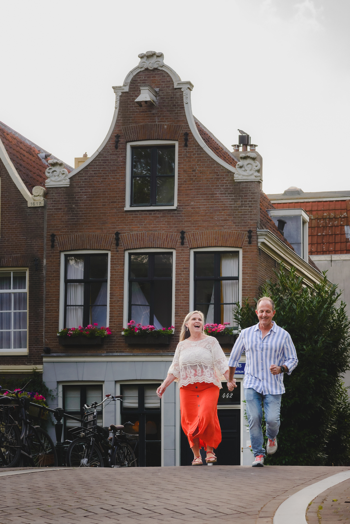 Couple walking along Amsterdam canal with historic buildings