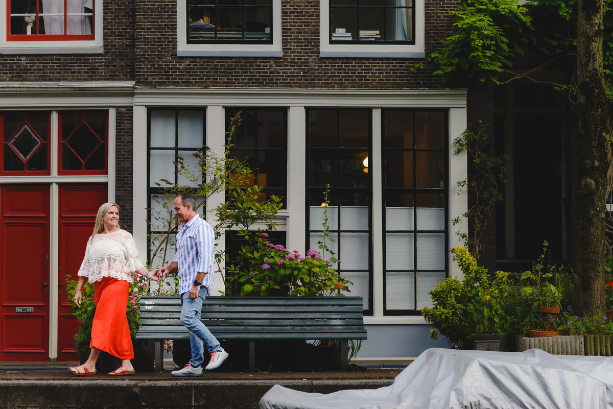 Couple walking along Amsterdam canal with historic buildings