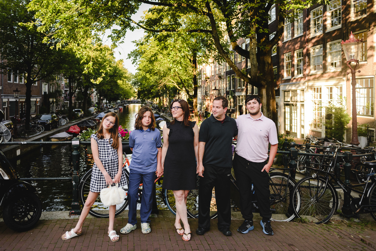 roup family photo in Amsterdam with canals, bicycles, and traditional houses