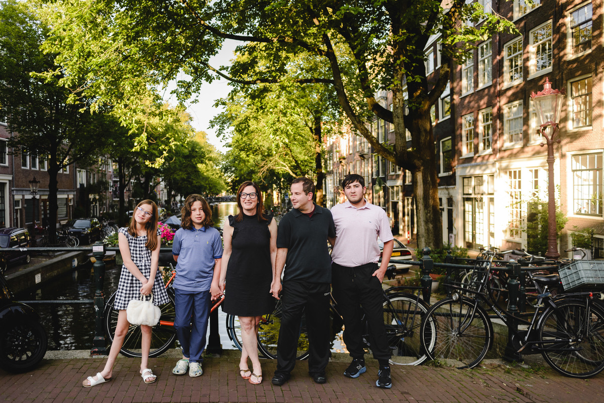 roup family photo in Amsterdam with canals, bicycles, and traditional houses