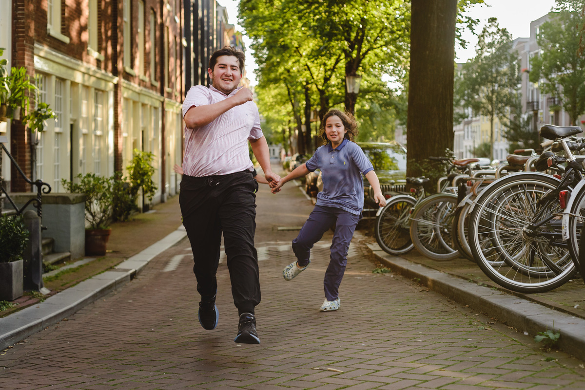 Siblings playing together during family photo session in Amsterdam