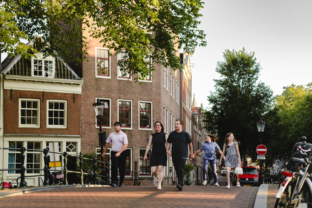 Family walking along an Amsterdam canal during a relaxed vacation photo session