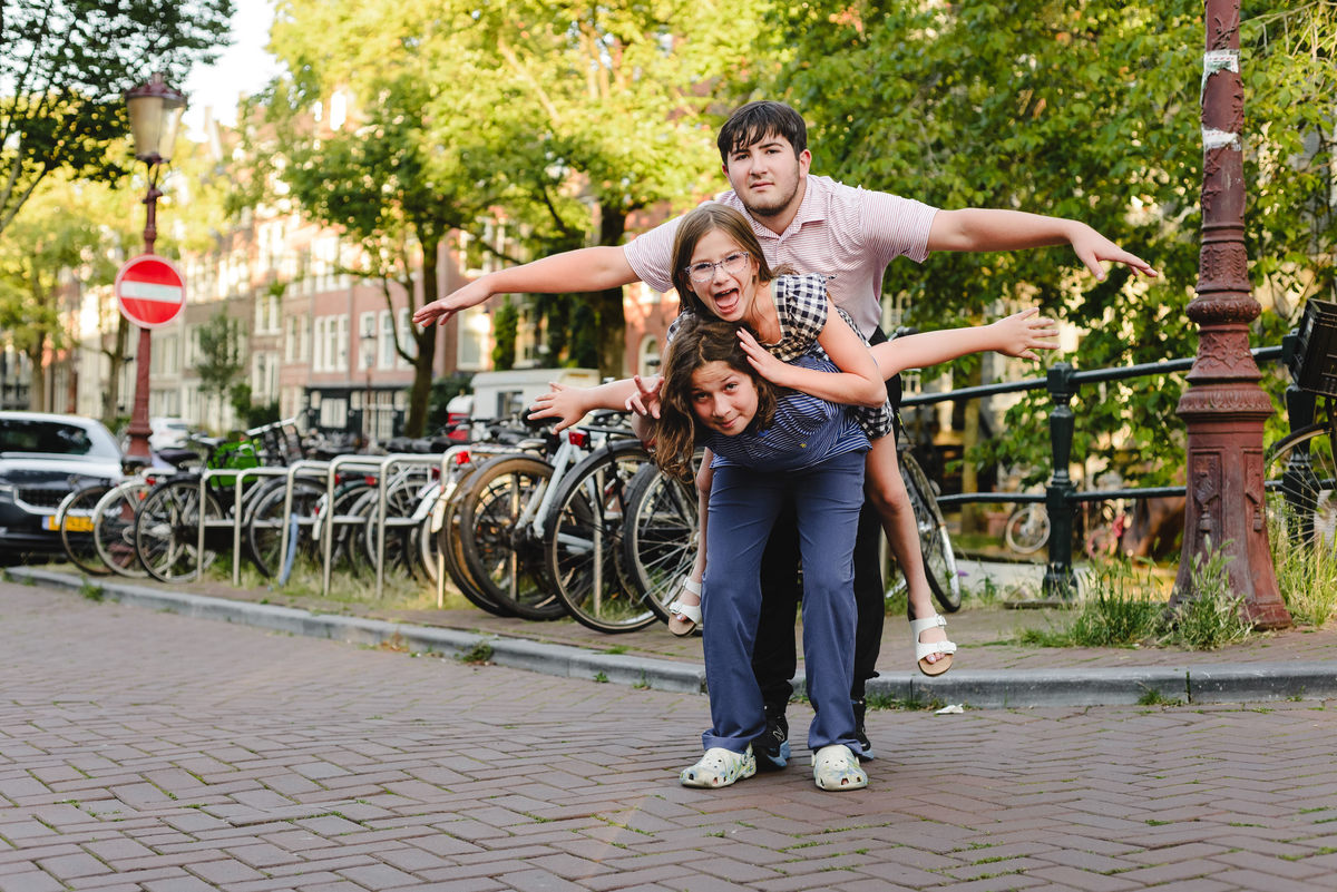 Siblings playing together during family photo session in Amsterdam