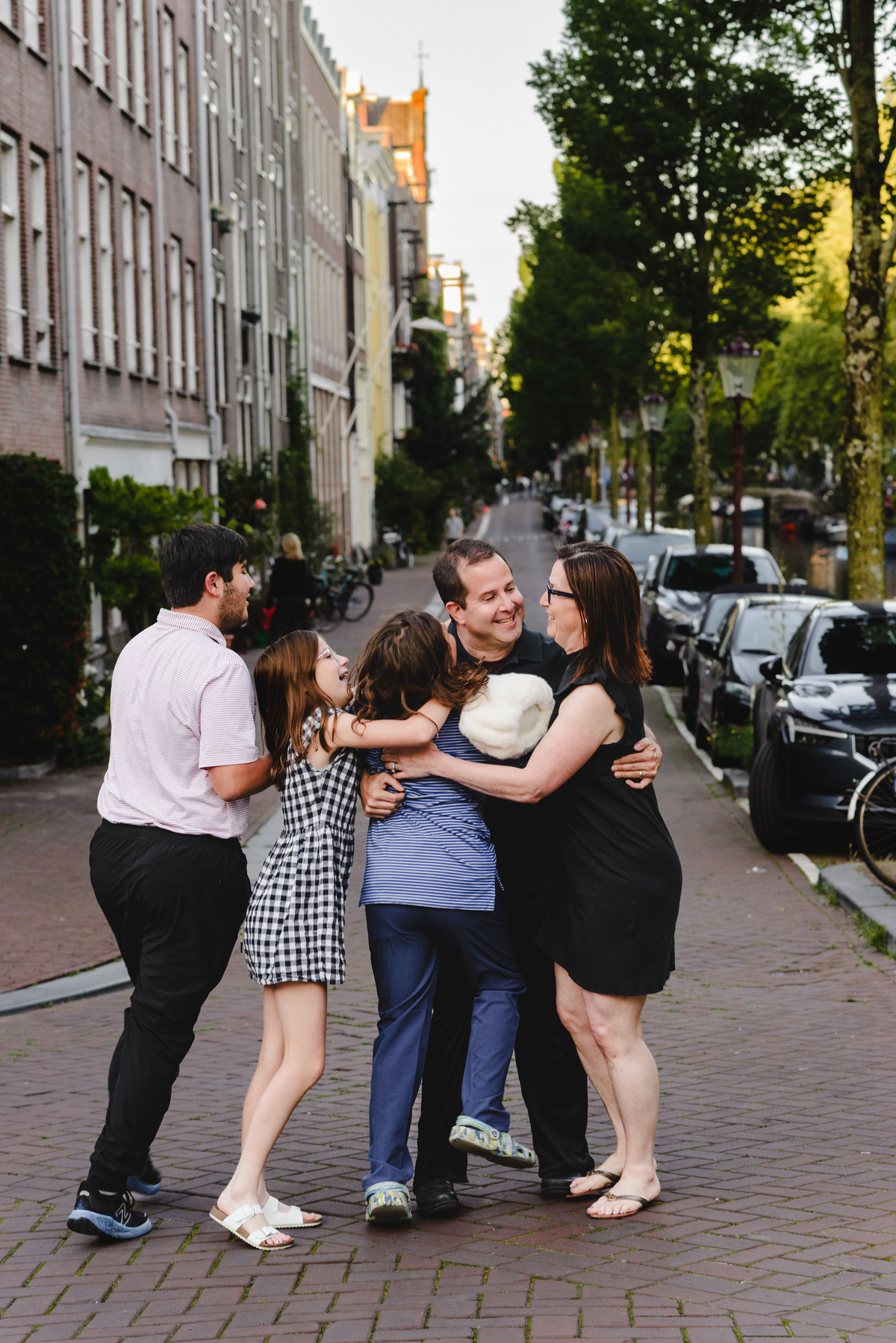Group family photo in Amsterdam with canals, bicycles, and traditional houses