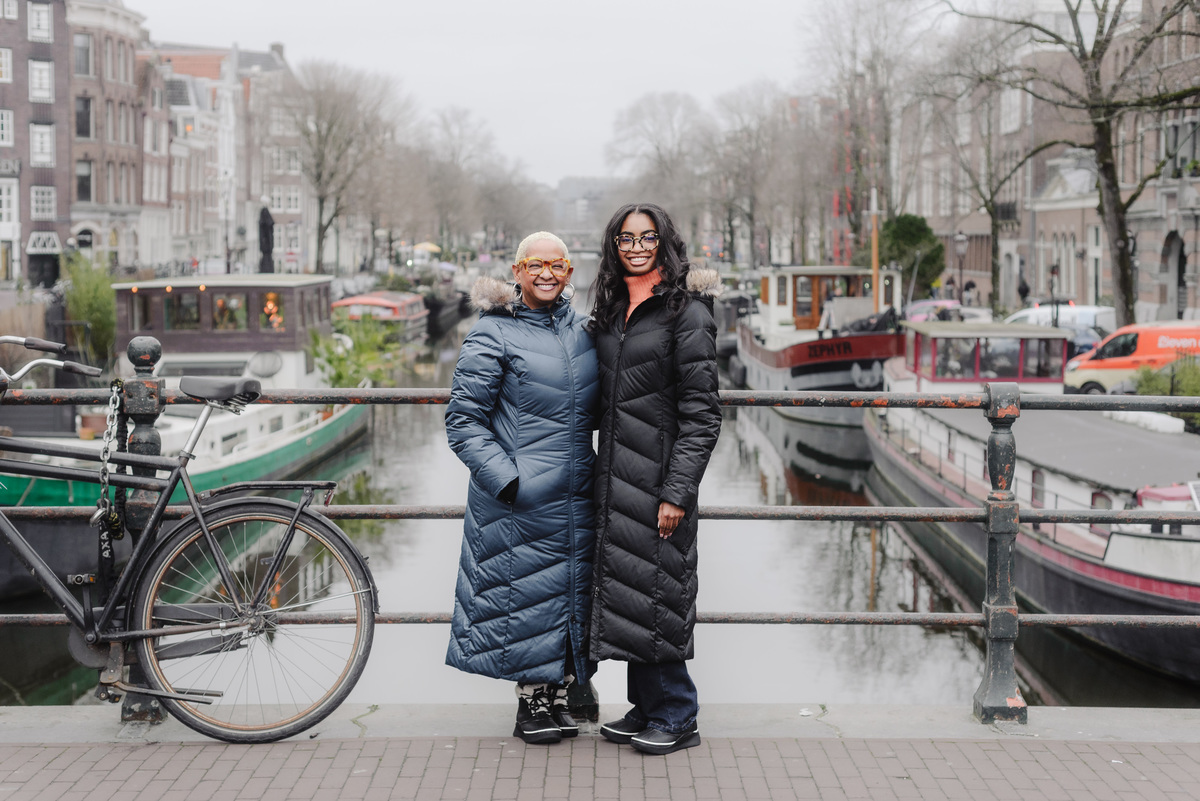 Mother and daughter walking hand in hand along Amsterdam canals during a holiday photo shoot