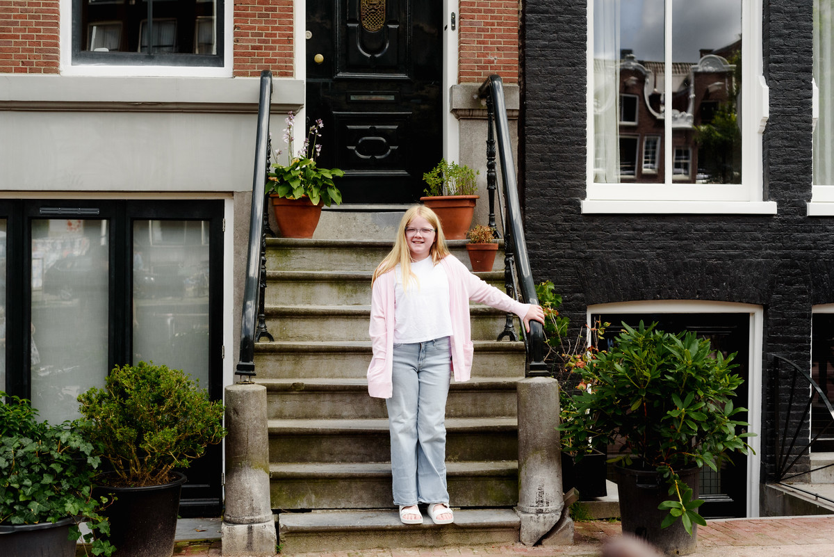 teenager standing on the stairs in front of an Amsterdam historic house