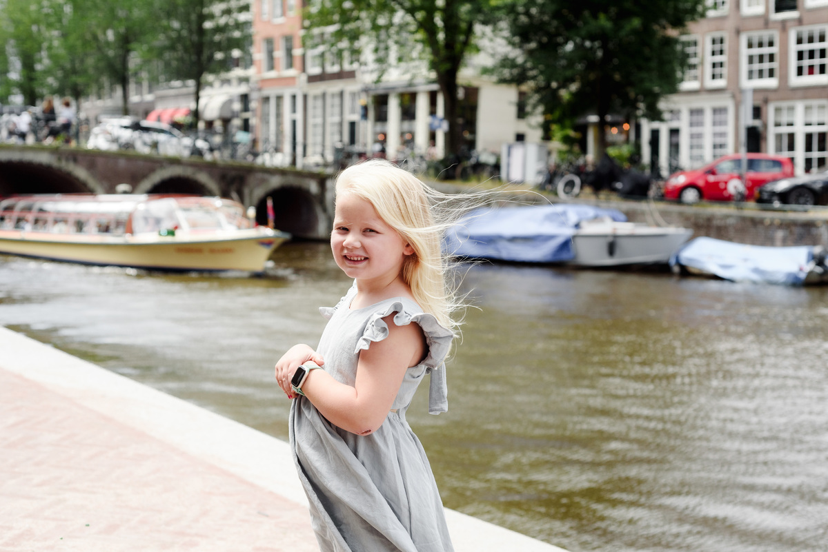 kid standing in front of a canal in Amsterdam