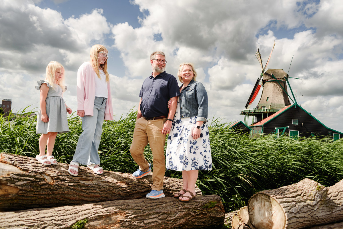 Family portrait with traditional Dutch windmills in background