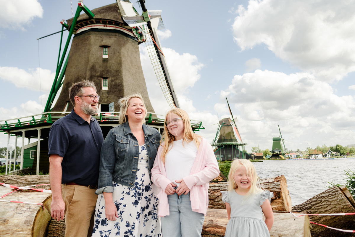 Family portrait with traditional Dutch windmills in background
