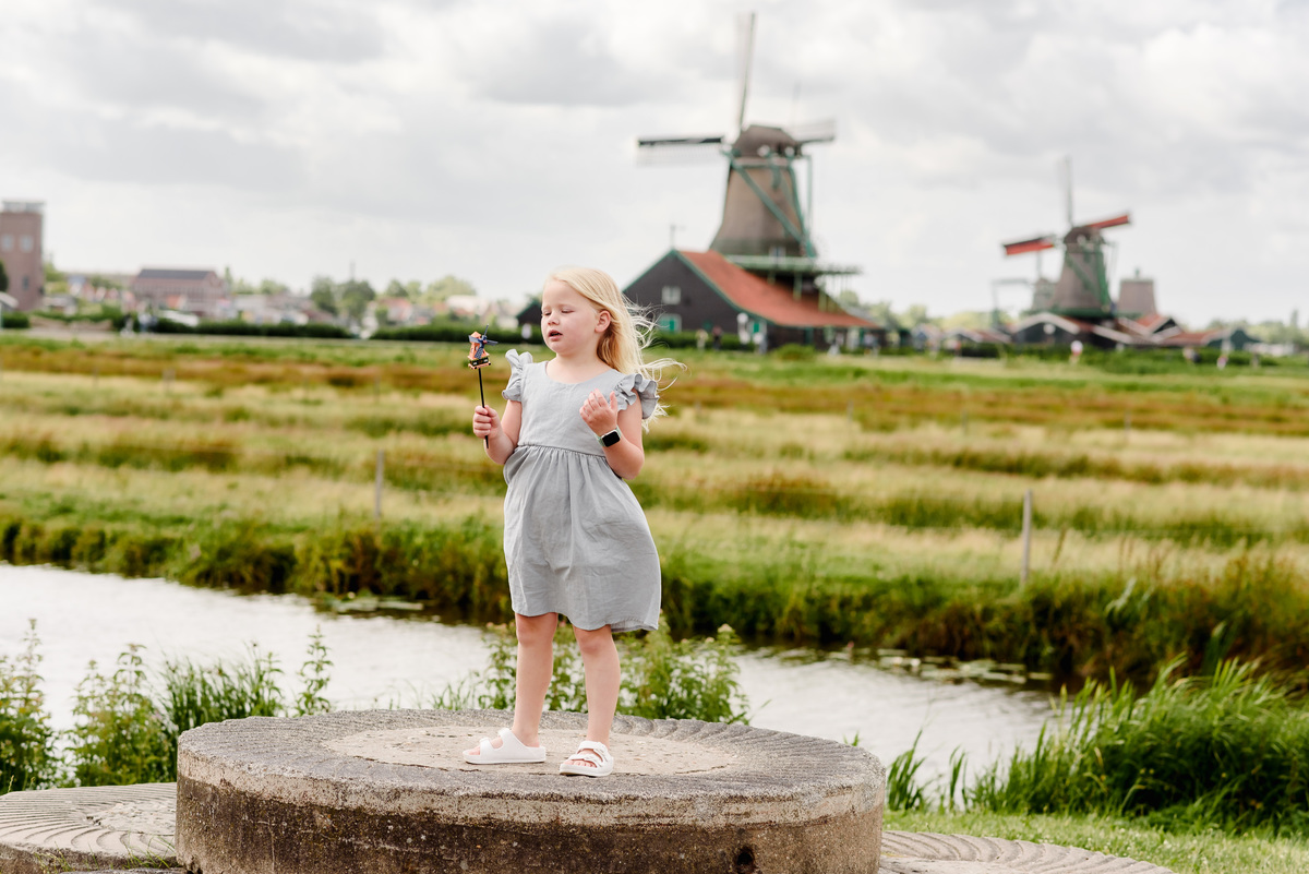 Kid portrait with famous windmills in the background at Zaanse Schans village