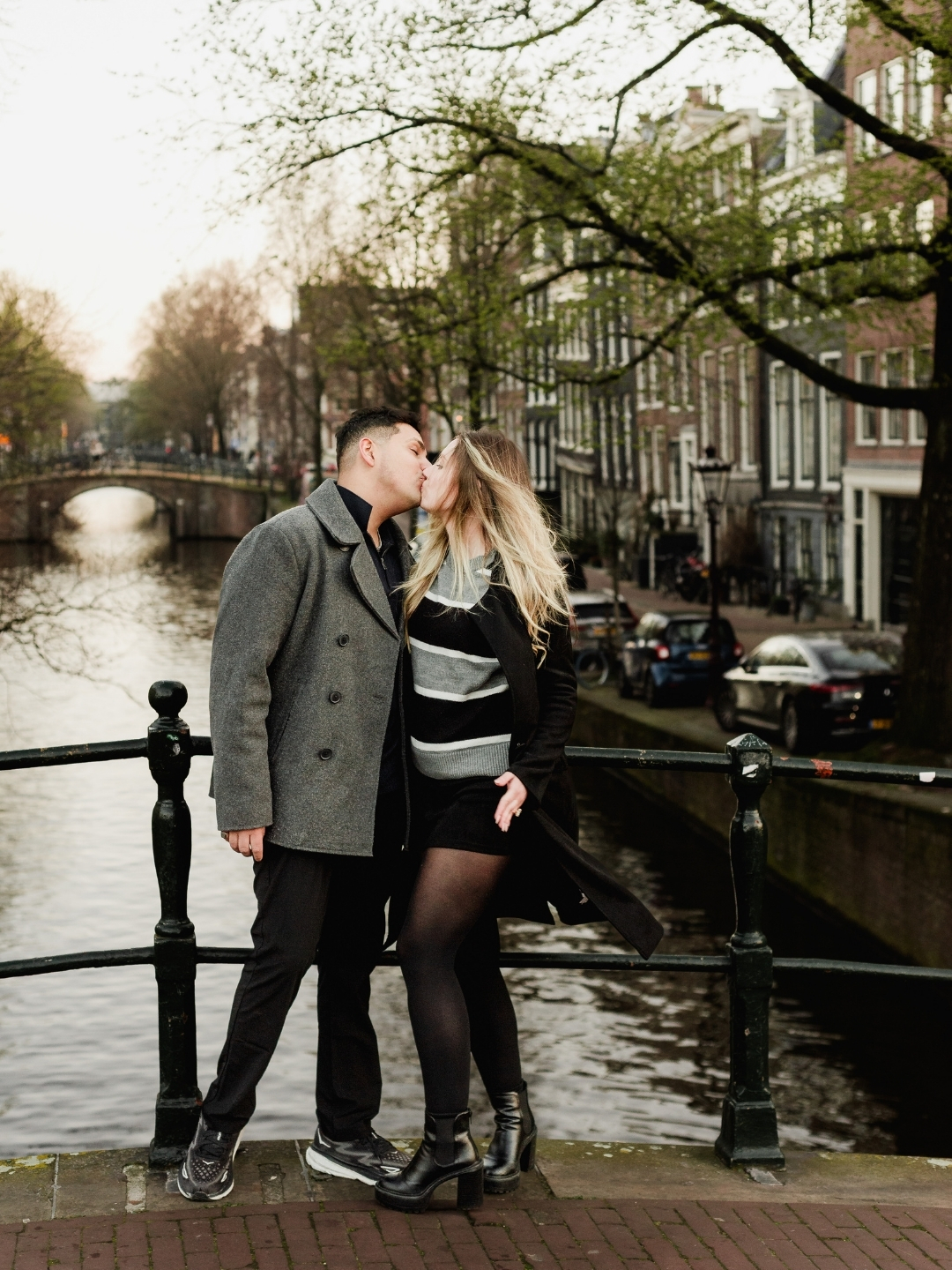 Newly engaged couple walking along Amsterdam canals after proposal