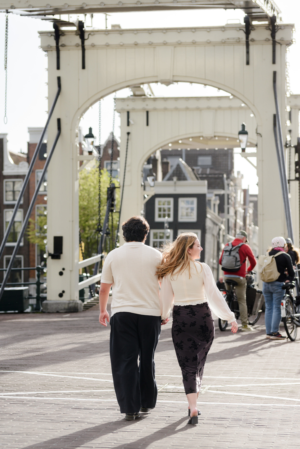 Couple walking on the streets of Amsterdam. They are recently engaged and crossing the skinny bridge 
