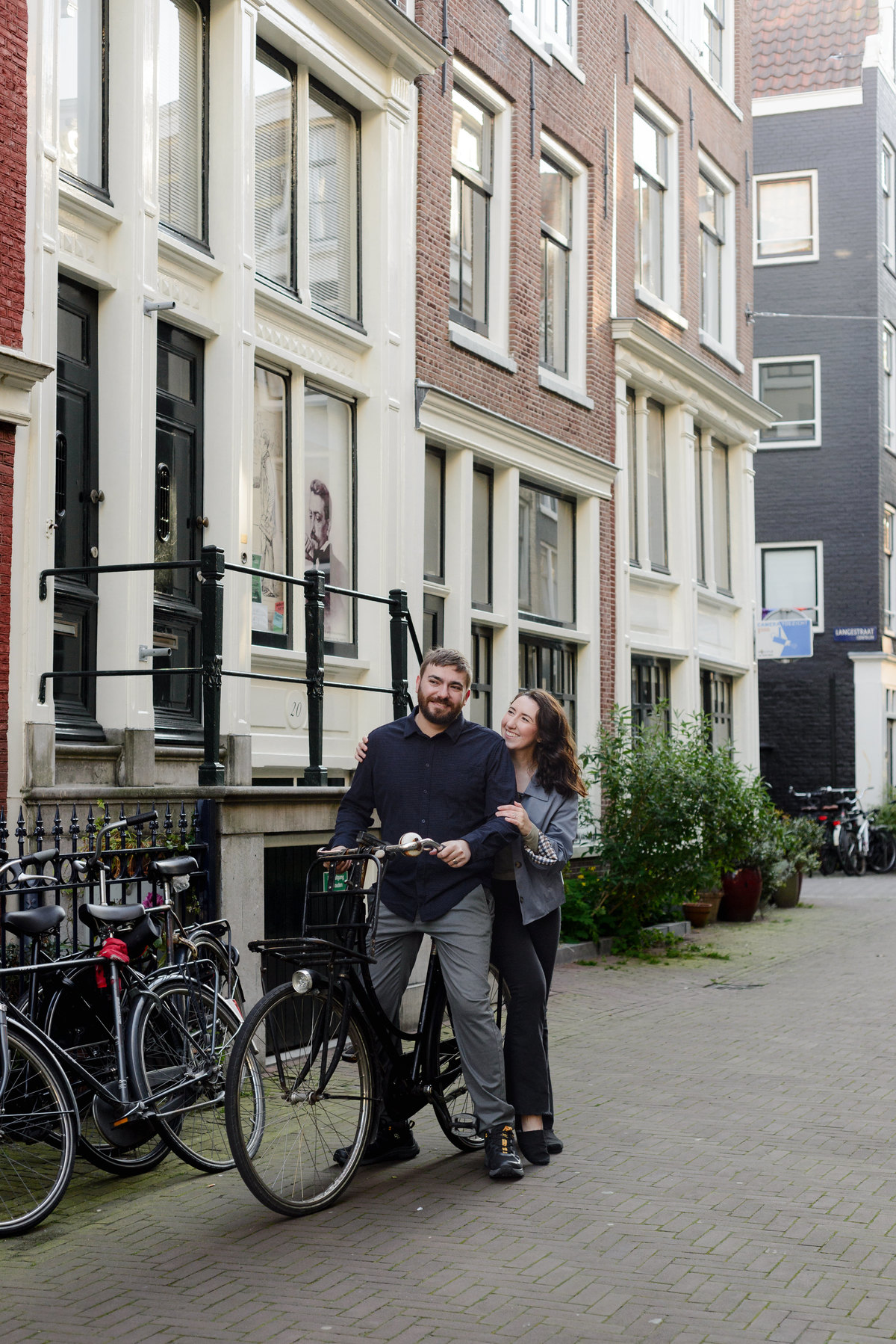 Couple riding a bicycle in Amsterdam during a photo session in the canal belt. 