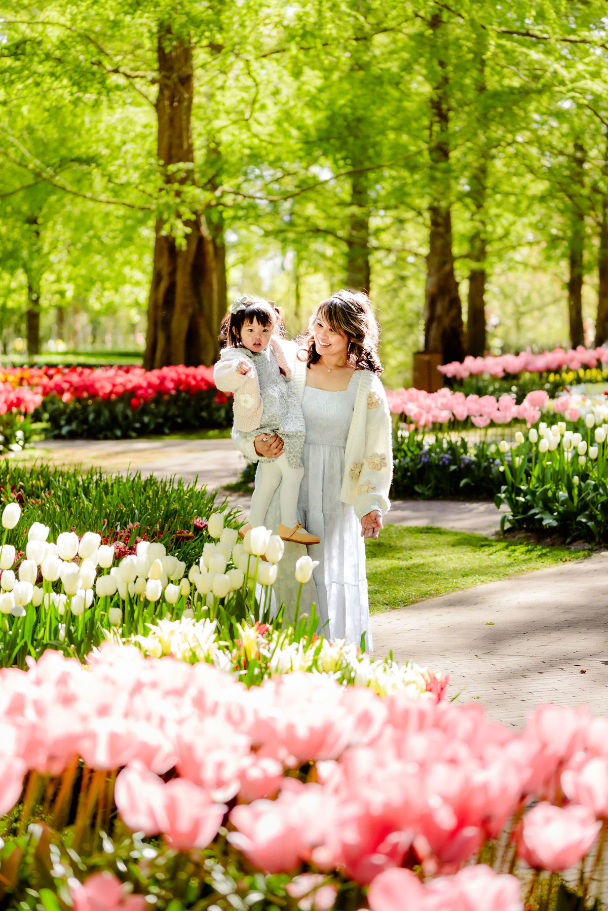 Mother and daughter walking together through colorful flower beds at Keukenhof