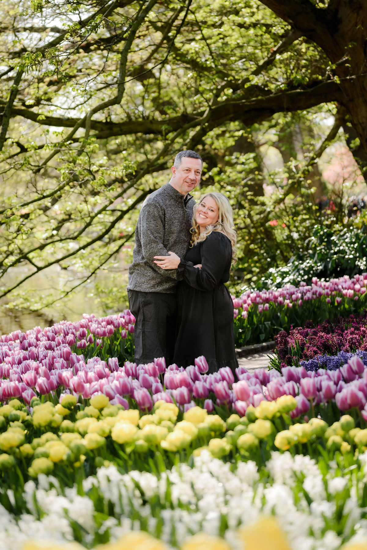 Couple exploring Keukenhof Gardens surrounded by colorful tulip displays