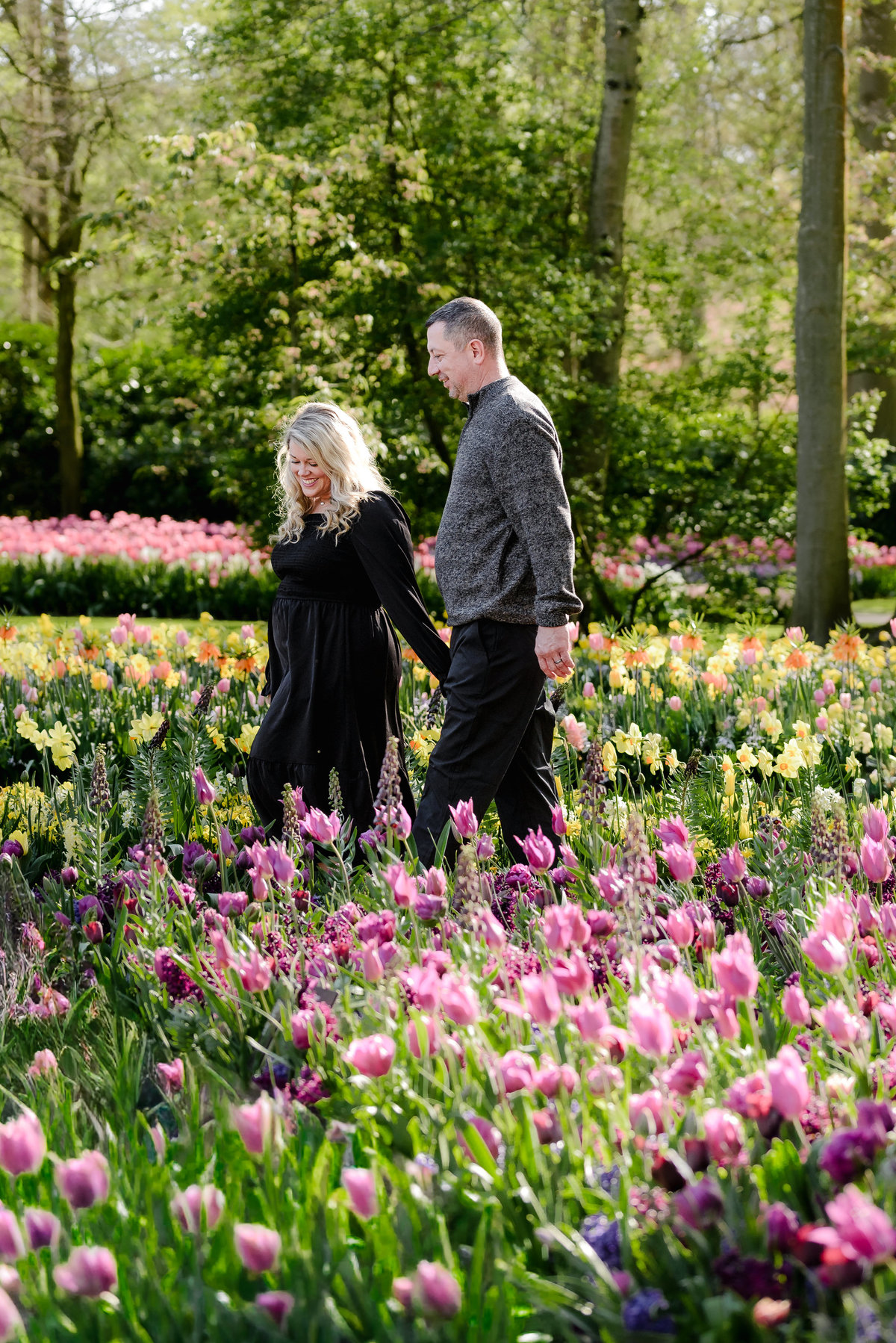 Couple exploring Keukenhof Gardens surrounded by colorful tulip displays