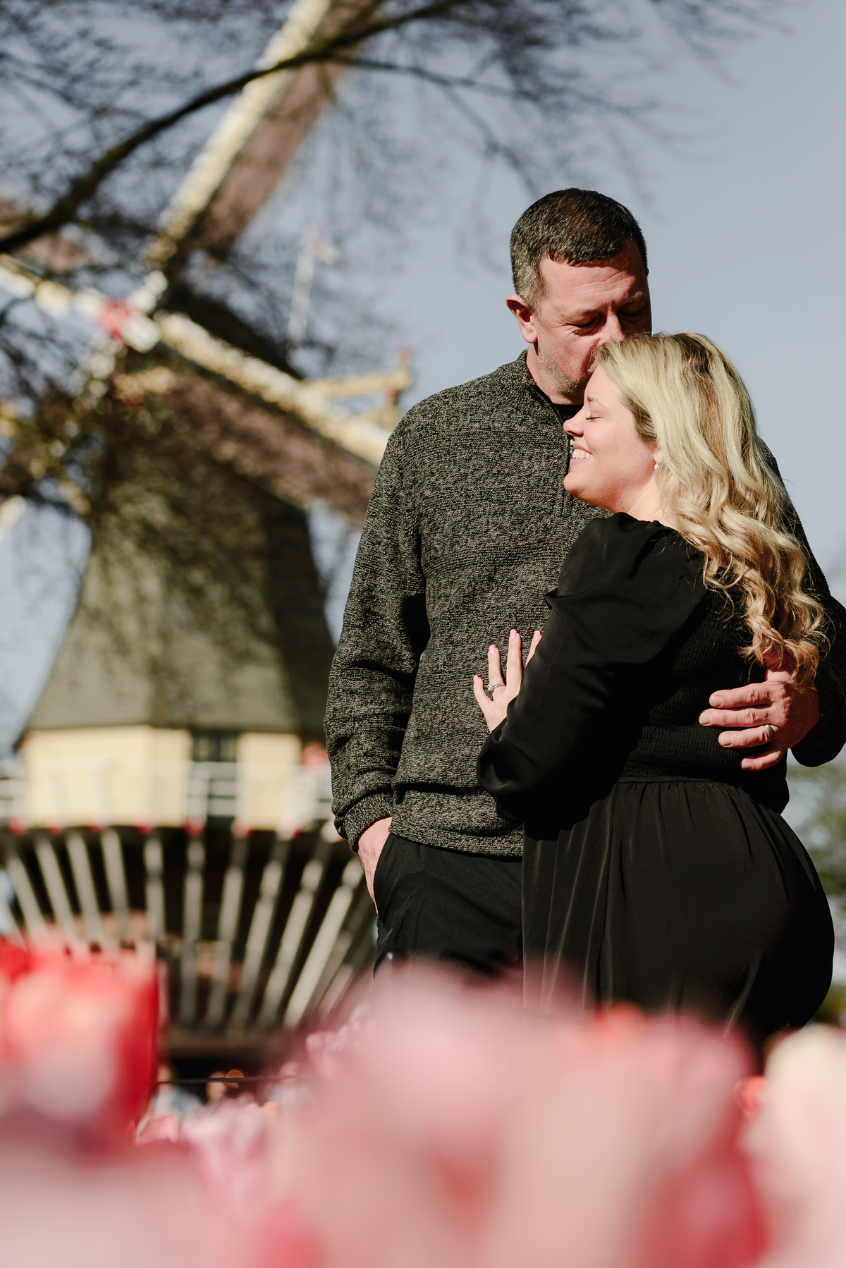 Couple portrait with a traditional Dutch windmill at Keukenhof Gardens